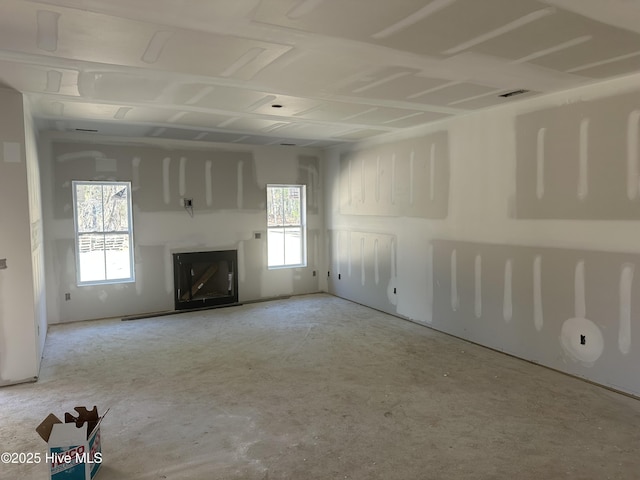 unfurnished living room featuring a fireplace, plenty of natural light, and visible vents