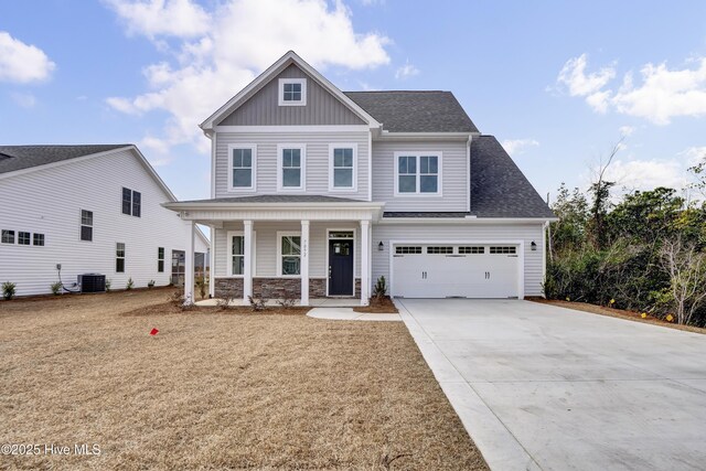 craftsman inspired home featuring covered porch, concrete driveway, a garage, central air condition unit, and board and batten siding