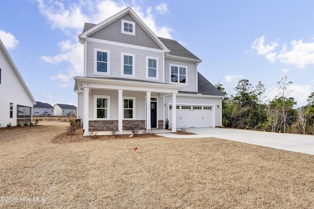 craftsman-style house featuring driveway, a porch, an attached garage, stone siding, and board and batten siding