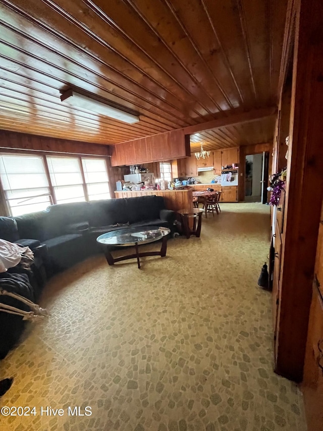 carpeted living room featuring wooden walls and wood ceiling