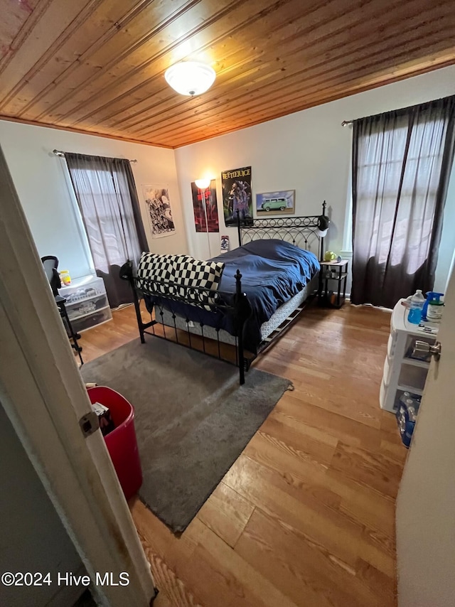 bedroom featuring multiple windows, wooden ceiling, and hardwood / wood-style flooring