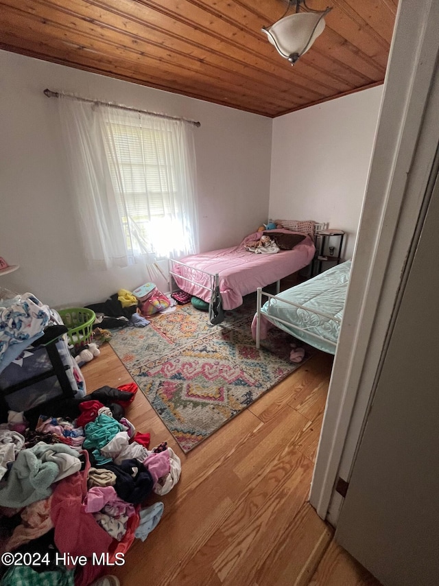 bedroom with hardwood / wood-style floors and wood ceiling