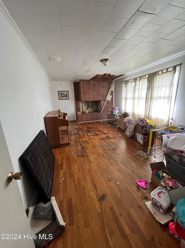 living room featuring a fireplace, hardwood / wood-style flooring, and crown molding