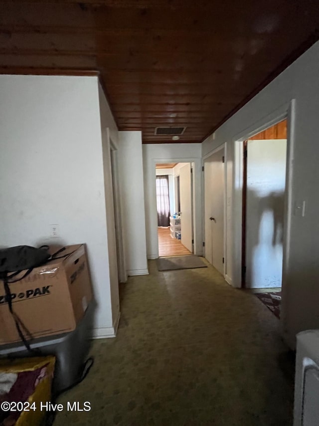 hallway with carpet floors and wood ceiling