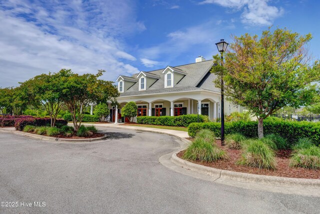 2786 Longleaf Pine Cir, Leland, NC 28451 - cape cod house featuring a porch, a chimney, and french doors