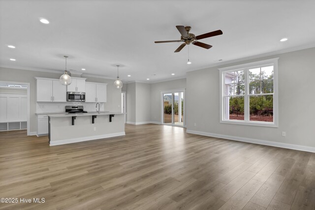 2786 Longleaf Pine Cir, Leland, NC 28451 - unfurnished living room featuring ceiling fan, ornamental molding, recessed lighting, wood finished floors, and a fireplace with flush hearth