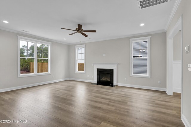 2786 Longleaf Pine Cir, Leland, NC 28451 - unfurnished living room with crown molding, healthy amount of natural light, light wood finished floors, ceiling fan, and a fireplace with flush hearth