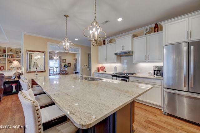 kitchen featuring sink, light hardwood / wood-style flooring, a center island with sink, white cabinets, and appliances with stainless steel finishes