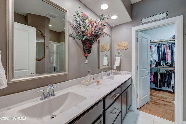 bathroom featuring hardwood / wood-style floors, vanity, and walk in shower