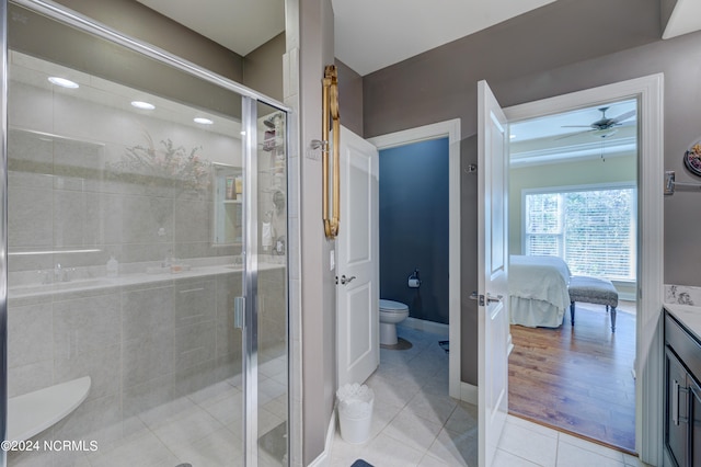 bathroom featuring vanity, a shower with door, ceiling fan, hardwood / wood-style floors, and toilet