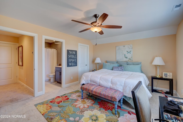 bedroom featuring ensuite bath, ceiling fan, and light colored carpet