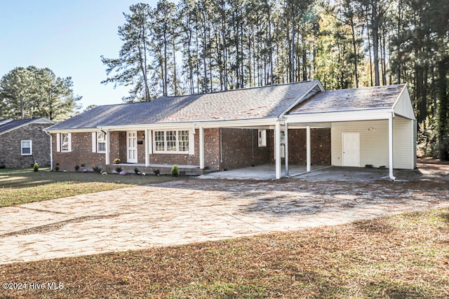 single story home featuring a carport and a front lawn