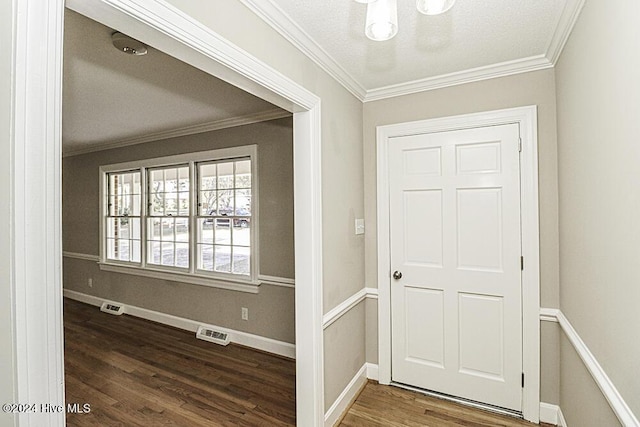 foyer entrance featuring ornamental molding, dark wood-type flooring, and a textured ceiling