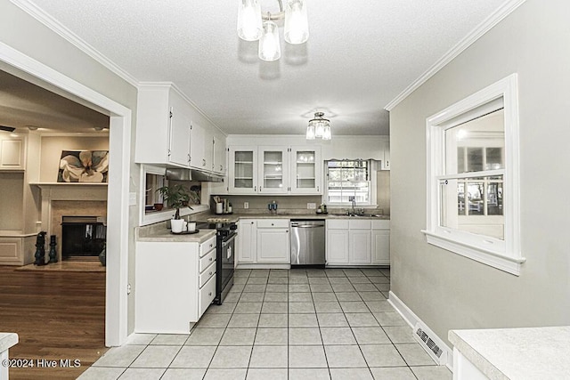 kitchen featuring light tile patterned floors, sink, dishwasher, white cabinets, and black range with electric cooktop