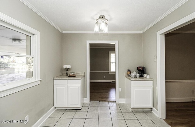 unfurnished dining area featuring a notable chandelier, ornamental molding, a textured ceiling, and light tile patterned floors