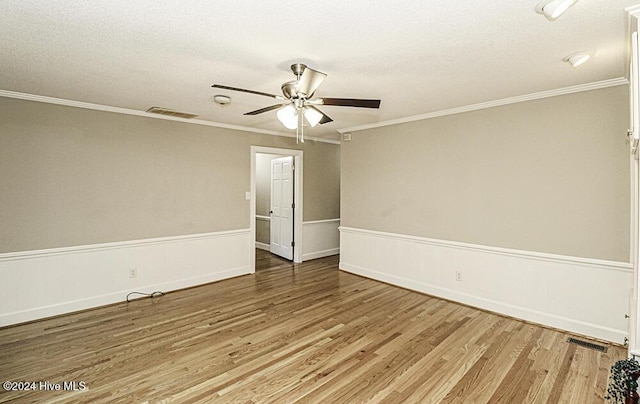 spare room with crown molding, wood-type flooring, and ceiling fan