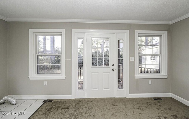 carpeted foyer featuring ornamental molding and a textured ceiling