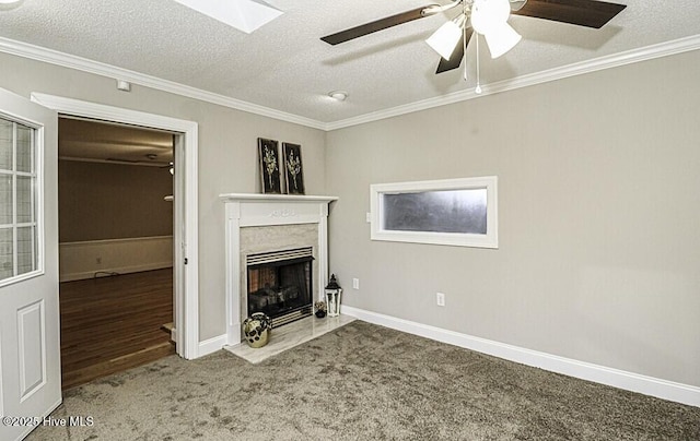 unfurnished living room with crown molding, ceiling fan, carpet flooring, a high end fireplace, and a textured ceiling