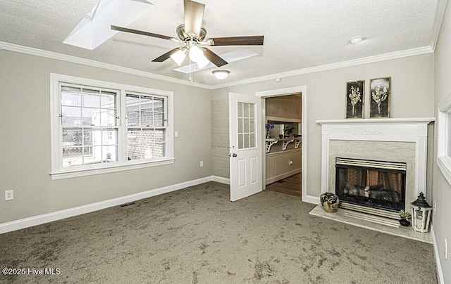 unfurnished living room featuring ceiling fan, a fireplace, carpet floors, ornamental molding, and a textured ceiling