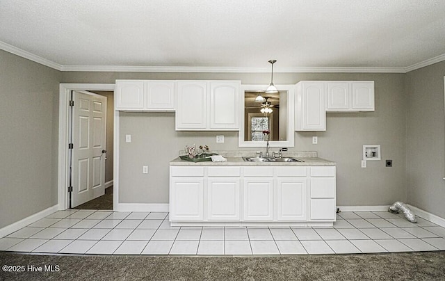 kitchen featuring hanging light fixtures, white cabinetry, sink, and light tile patterned flooring