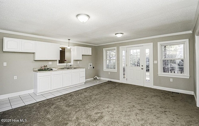 kitchen with white cabinetry, light colored carpet, sink, and hanging light fixtures