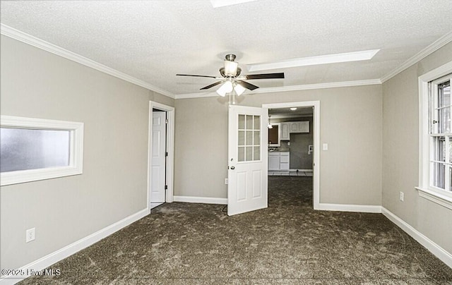 carpeted empty room with ceiling fan, ornamental molding, and a textured ceiling