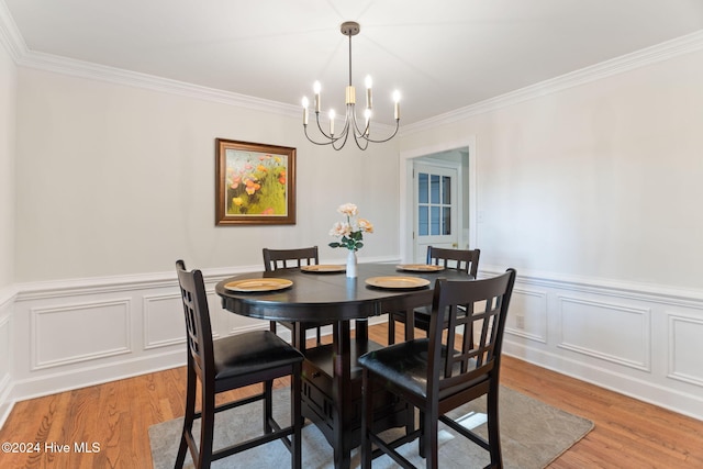 dining space featuring a notable chandelier, wood-type flooring, and ornamental molding