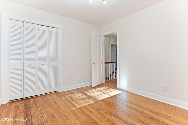 unfurnished bedroom featuring a closet and light hardwood / wood-style flooring