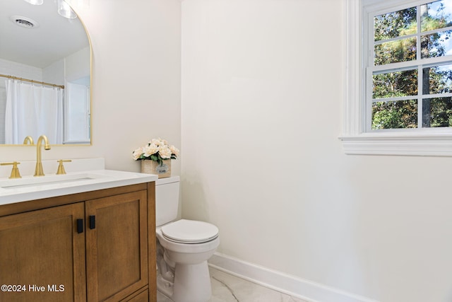 bathroom featuring tile patterned floors, vanity, toilet, and walk in shower