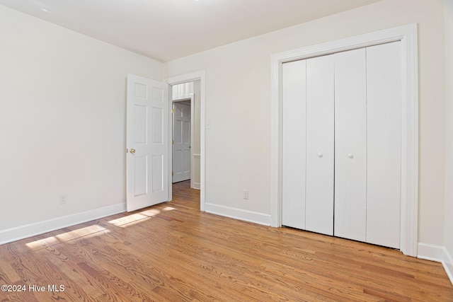 unfurnished bedroom featuring light wood-type flooring and a closet