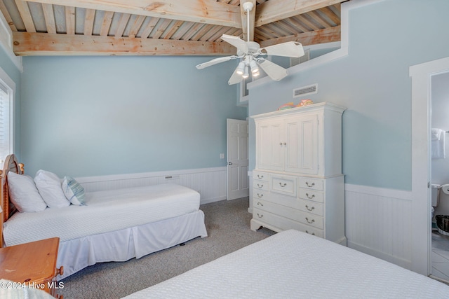 carpeted bedroom with vaulted ceiling with beams, ceiling fan, wooden walls, and wood ceiling