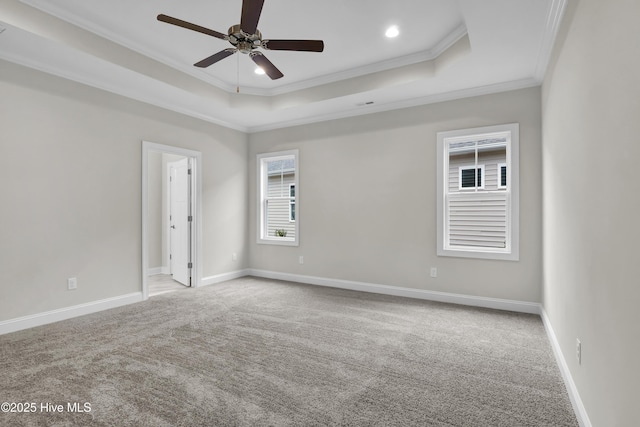 carpeted empty room with crown molding, ceiling fan, and a tray ceiling