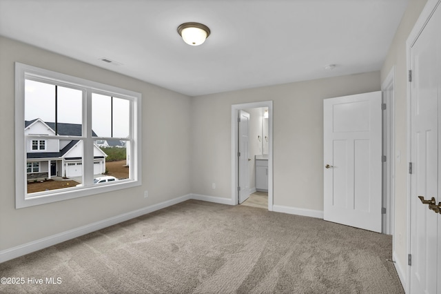 unfurnished bedroom with light carpet and ensuite bath