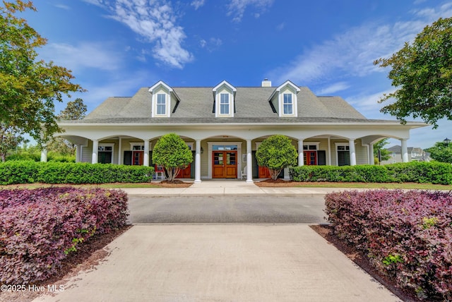 cape cod-style house with french doors and covered porch