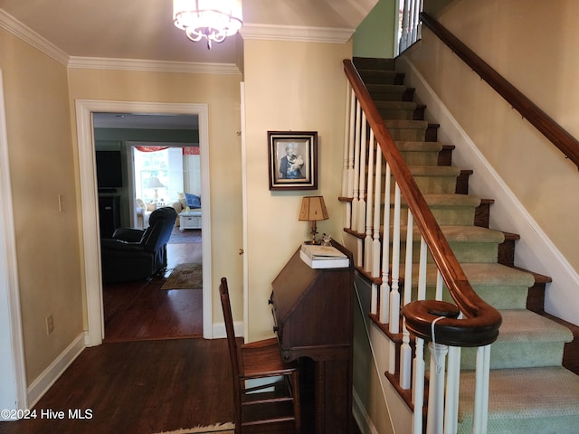 stairs featuring wood-type flooring, crown molding, and a chandelier