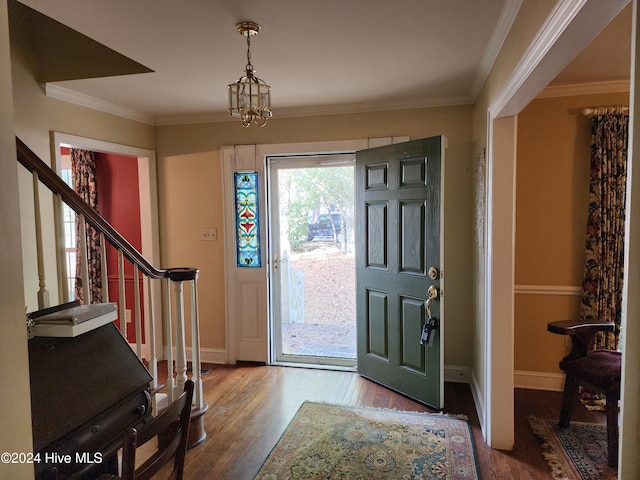 foyer featuring hardwood / wood-style flooring, a notable chandelier, and ornamental molding