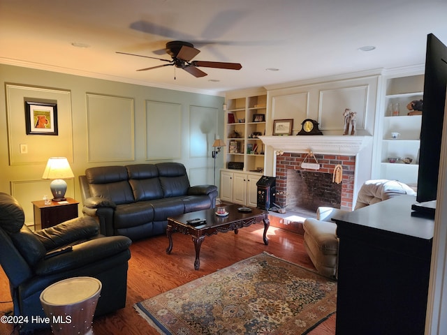 living room featuring crown molding, hardwood / wood-style floors, ceiling fan, and built in features