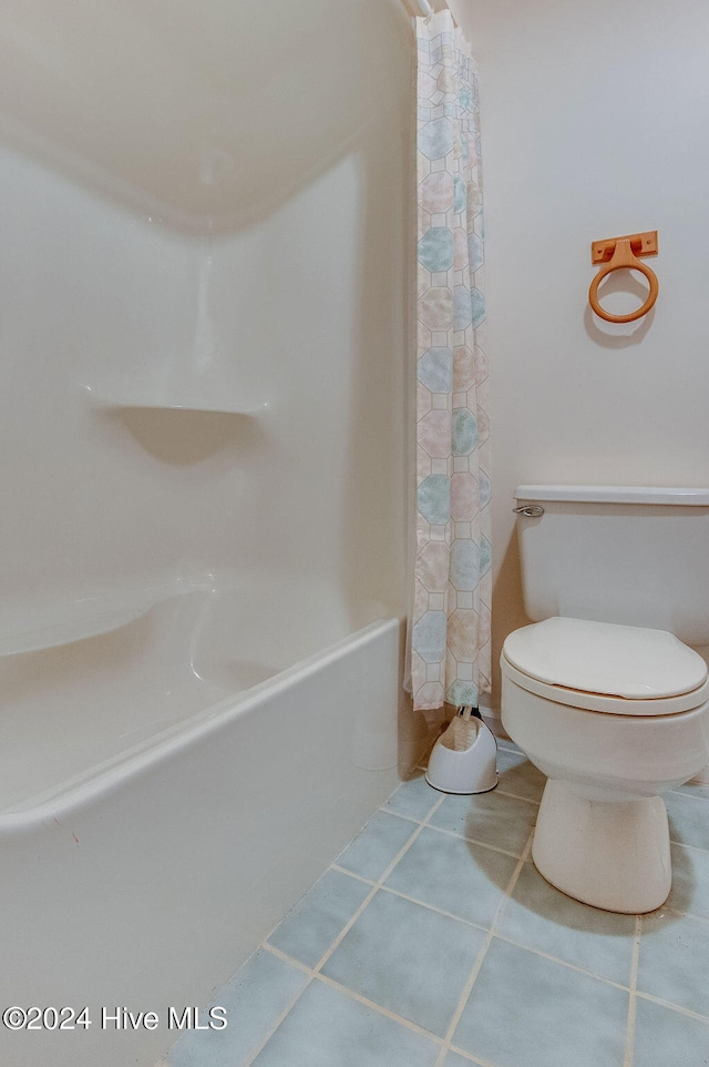 bathroom featuring tile patterned flooring, shower / tub combo, and toilet