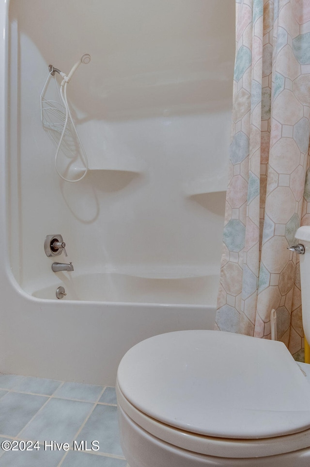 bathroom featuring toilet, tile patterned floors, and shower / bath combo with shower curtain