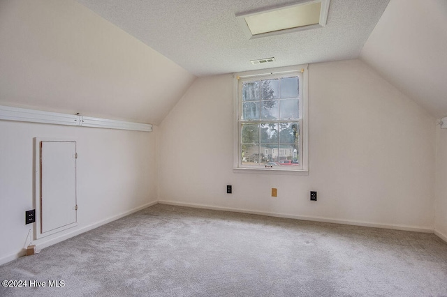 bonus room featuring light colored carpet, a textured ceiling, and vaulted ceiling