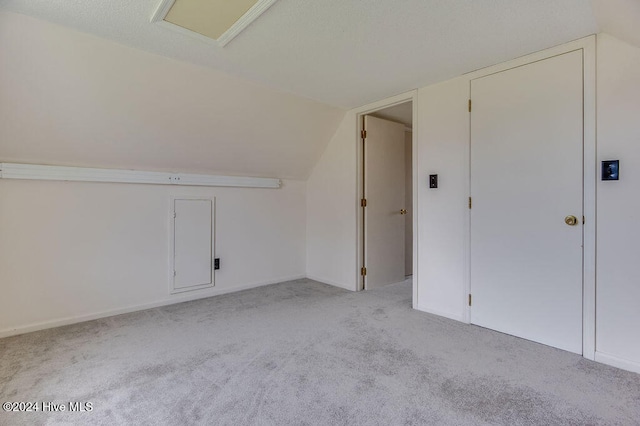 bonus room with light colored carpet and lofted ceiling