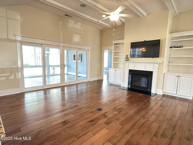 unfurnished living room featuring dark wood-style floors, a glass covered fireplace, and beam ceiling