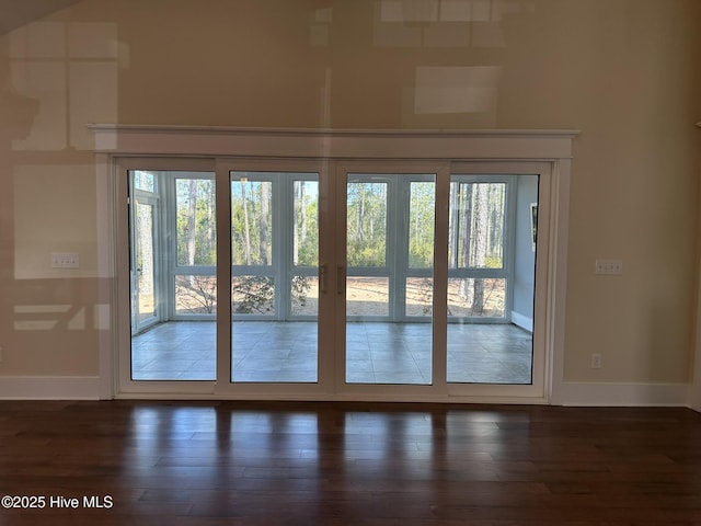 doorway to outside with a wealth of natural light, dark wood finished floors, and baseboards