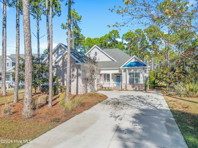 craftsman inspired home with concrete driveway and brick siding