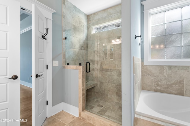 full bath featuring a shower stall, baseboards, and a bath