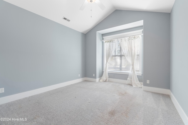 unfurnished room featuring carpet floors, lofted ceiling, visible vents, and ceiling fan