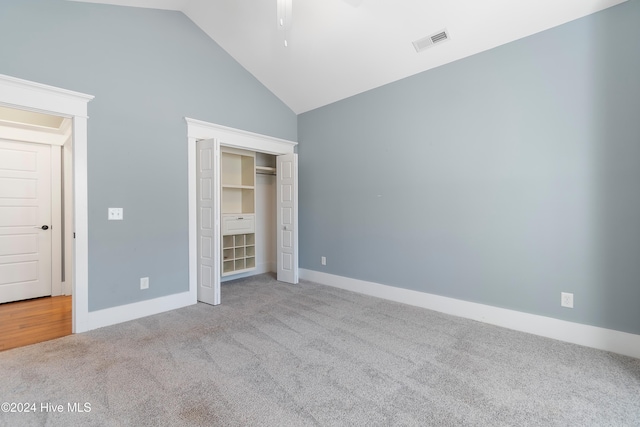 unfurnished bedroom featuring high vaulted ceiling, baseboards, visible vents, and light colored carpet