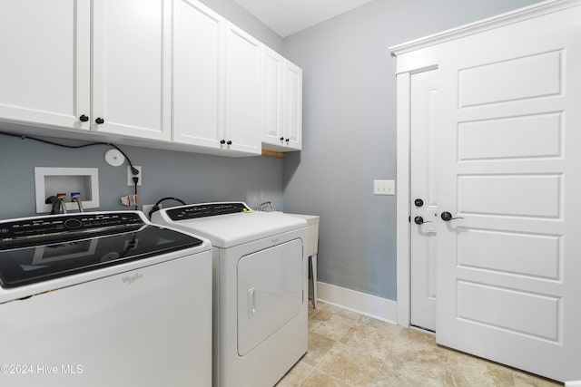 laundry room featuring washer and clothes dryer, cabinet space, and baseboards