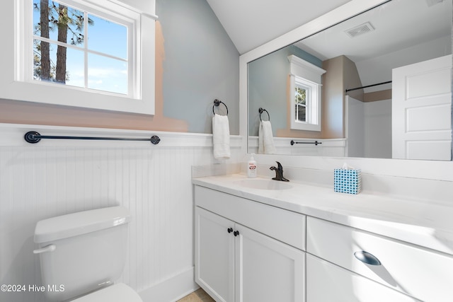 full bath featuring visible vents, wainscoting, toilet, walk in shower, and vanity