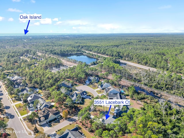 bird's eye view featuring a forest view, a water view, and a residential view